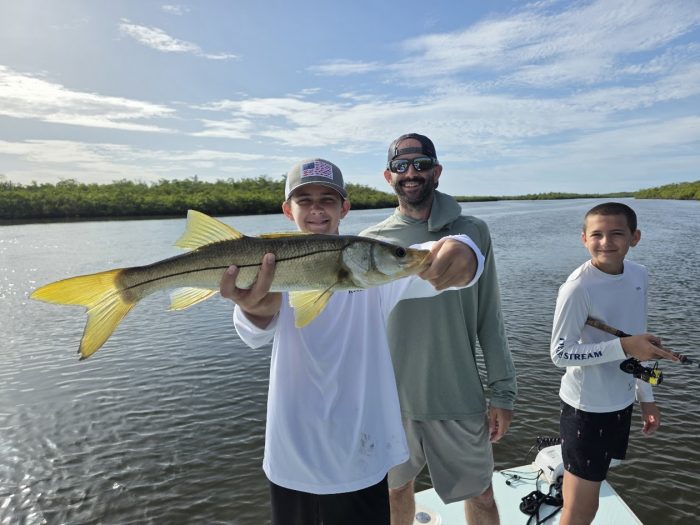 Mason holding a snook on a fishing charter