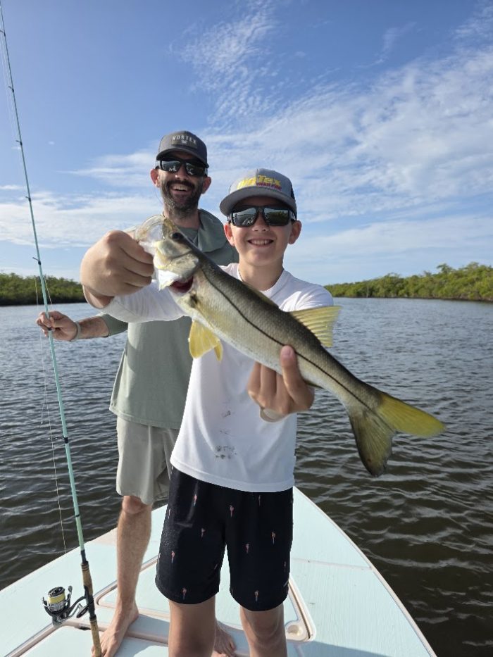 Nathan holding a snook on a fishing charter