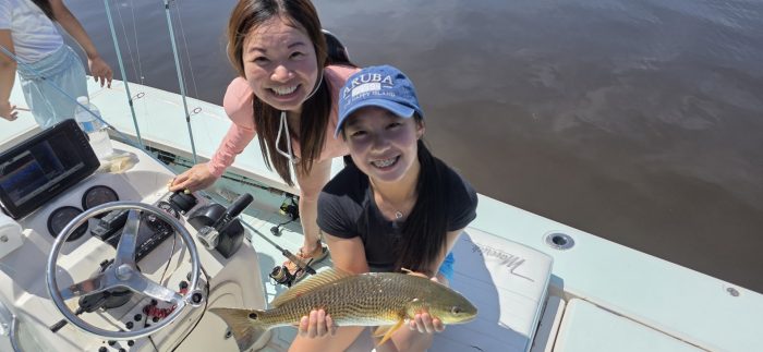 mom and daughter with a redfish